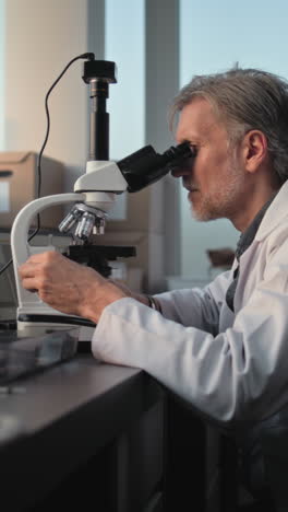 scientist using microscope in laboratory