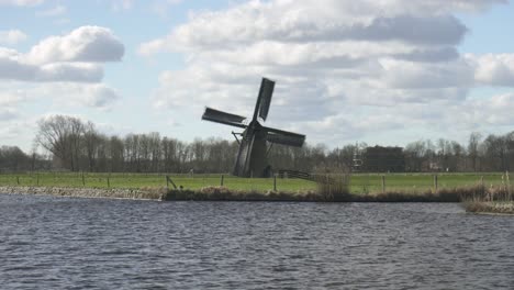 traditional dutch windmill knipmolen situated on a canal in voorschoten, netherlands