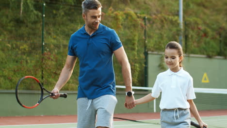 Amoroso-Papá-Y-Feliz-Hijita-Tomados-De-La-Mano-Y-Saliendo-Juntos-De-La-Cancha-De-Tenis