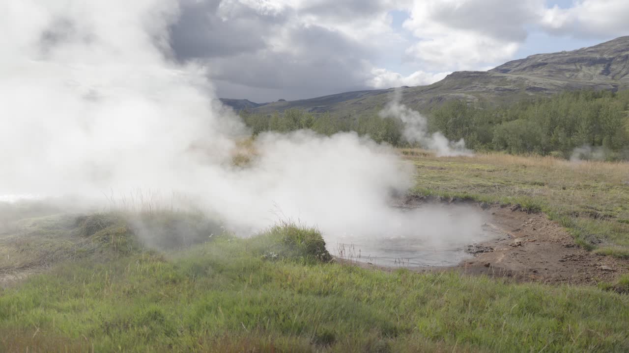 fotografía en cámara lenta de una fuente volcánica natural hirviendo que libera vapor en islandia