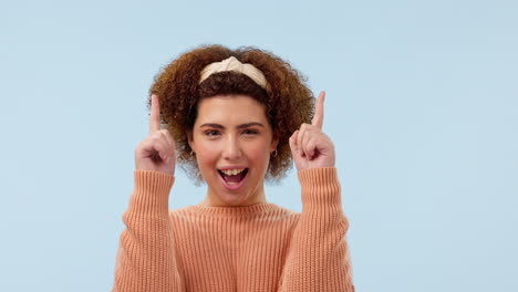 Happy,-face-and-woman-pointing-up-in-studio