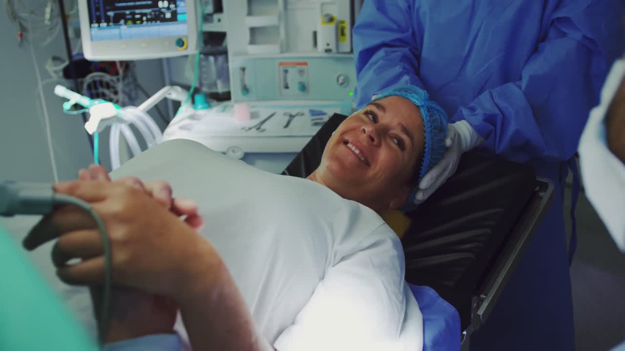 Primo piano di un uomo caucasico che conforta una donna incinta durante il travaglio in sala operatoria 4K