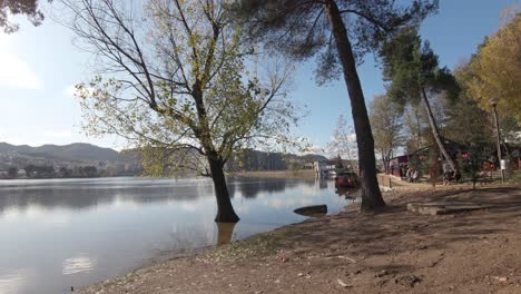 orilla del lago artificial del gran parque de tirana en un día soleado en albania - amplia toma de carro