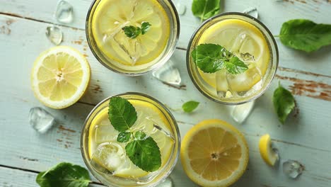 refreshing lemon drinks with mint on rustic wooden background