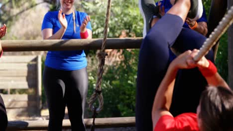 Women-applauding-female-trainer-while-rope-climbing