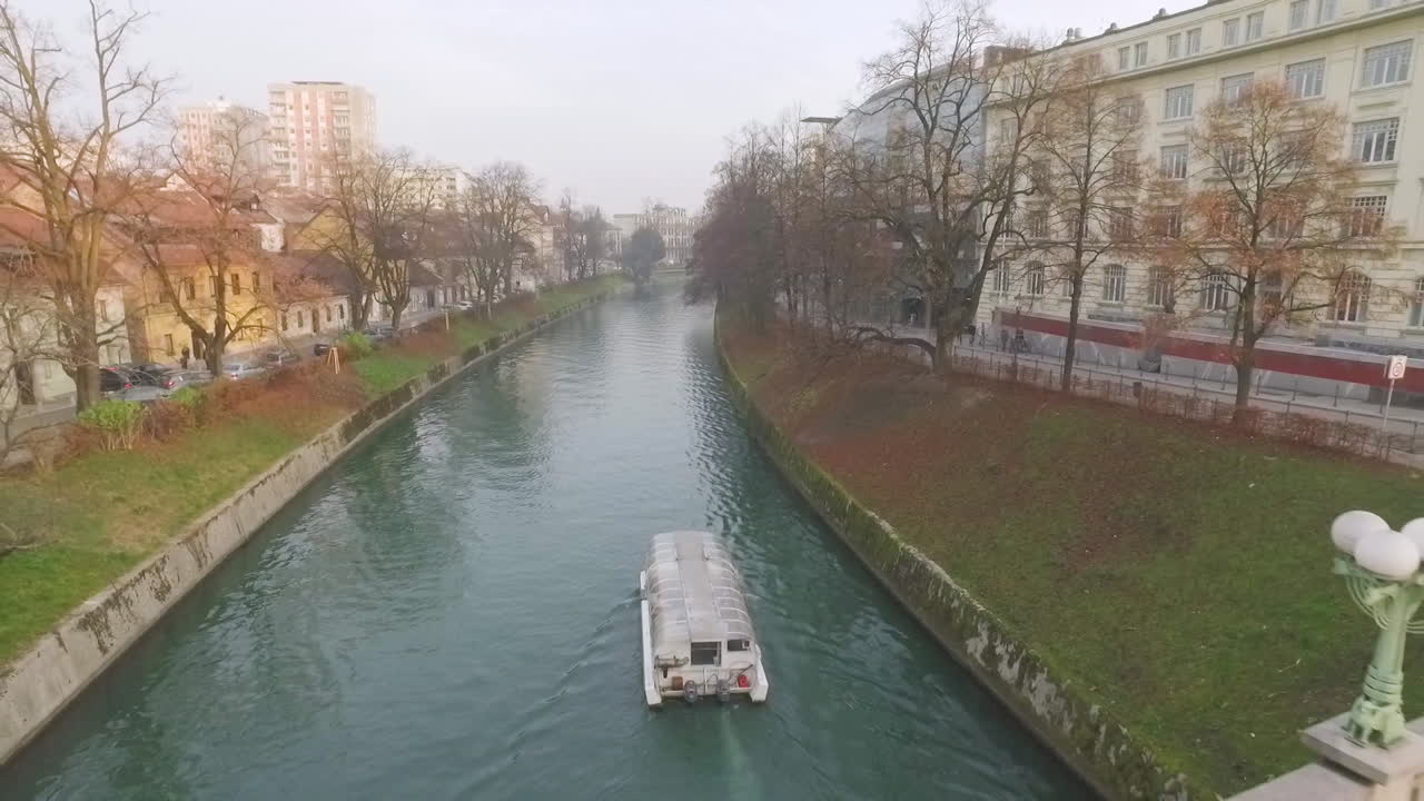 Little touristic boat cruise on its usual route over river Ljubljanica in Ljubljana, Slovenia.