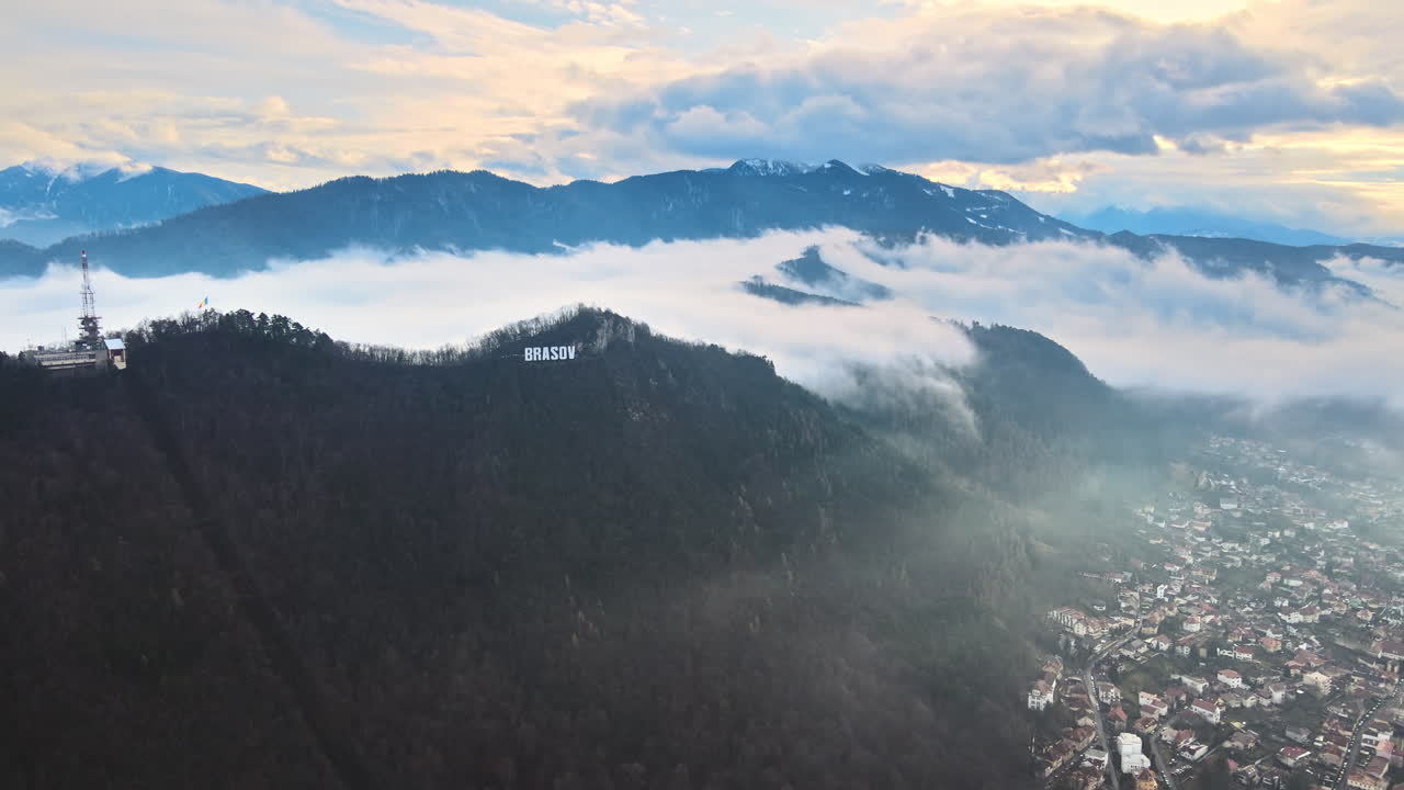 Brasov sign on the top of the hill near the city, bare trees, low clouds, cityscape, Romania