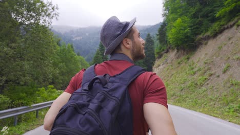 un joven caminando por un camino vacío.