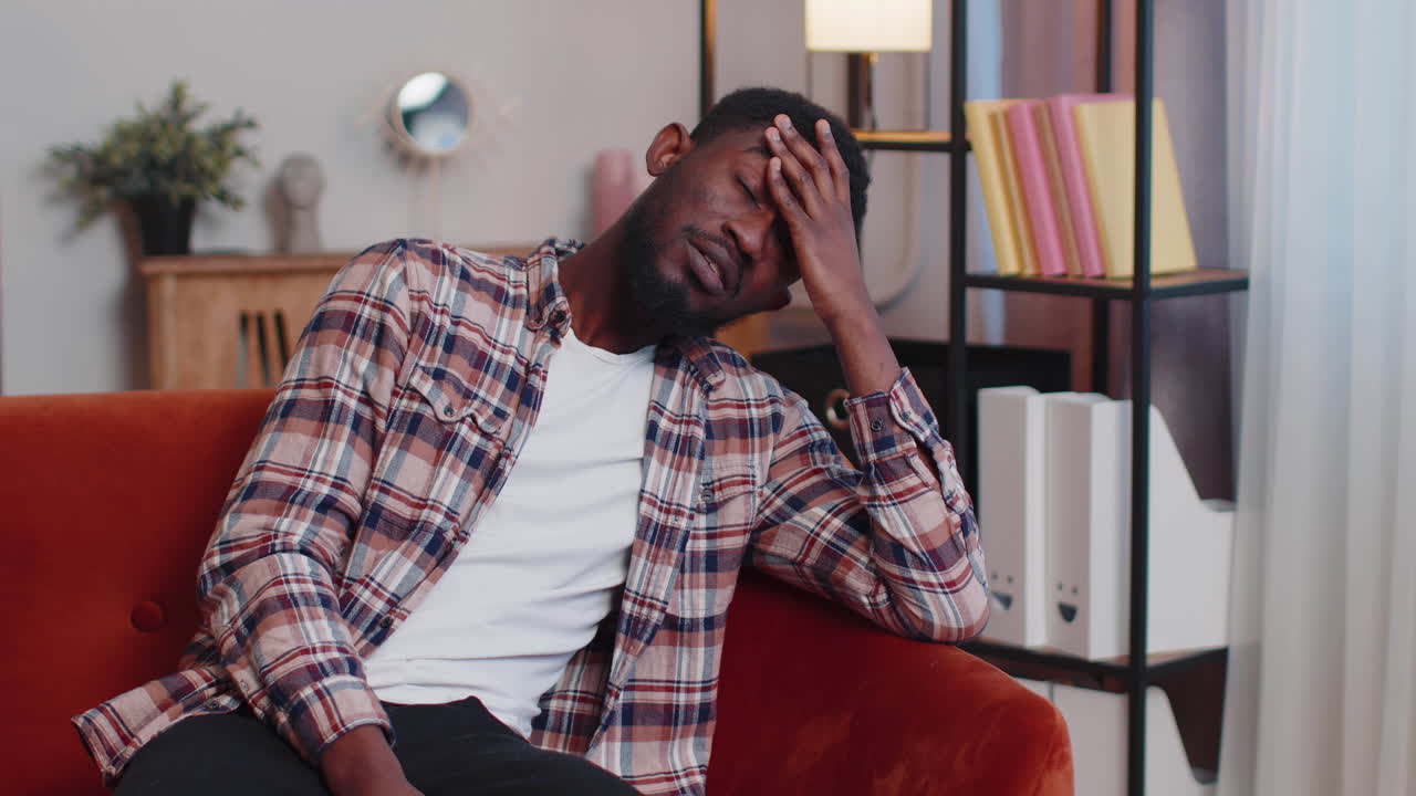 hombre afroamericano en casa sufre de una situación injusta problema, ruptura, deprimido, sintiéndose mal