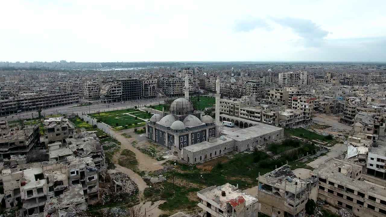 vista aérea de casas y mezquitas en ruinas en alepo, una ciudad destruida por los bombardeos, sólo quedan casas en ruinas, bajo el cielo azul.