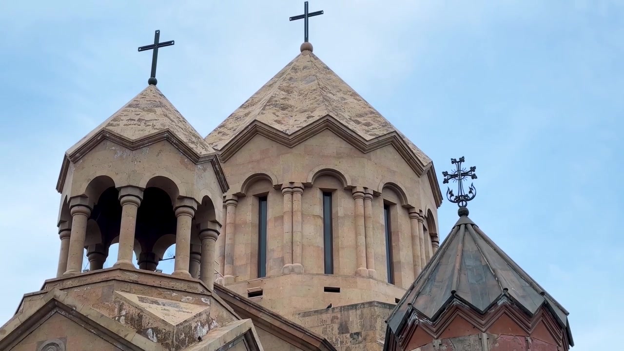 Architettura di chiesa con archi nella struttura esterna dell'edificio e portale d'ingresso con cupola sul tetto, in muratura di tufo vulcanico armeno, patrimonio di un antico e storico monastero religioso medievale.
