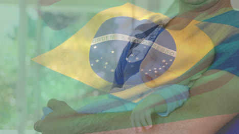 Animación-De-La-Bandera-De-Brasil-Sobre-Un-Hombre-Caucásico-Sosteniendo-A-Un-Bebé.