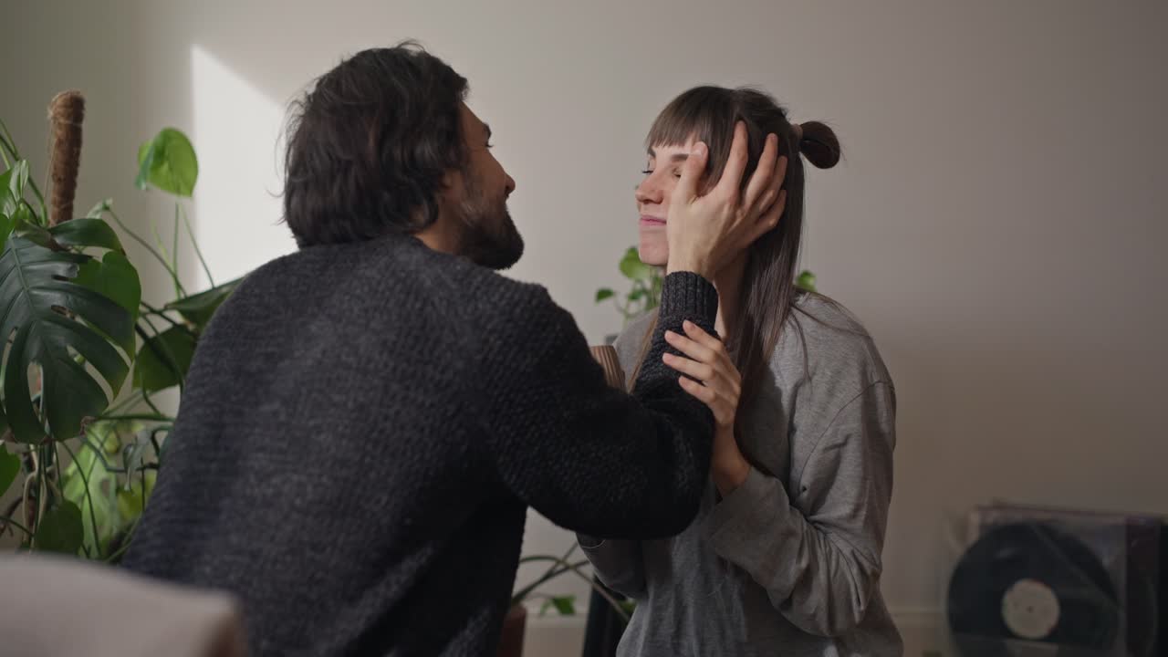 A couple sharing a tender moment amidst indoor plants
