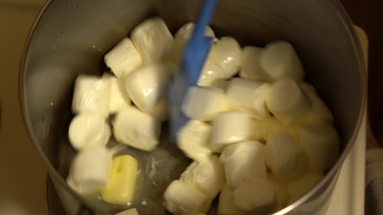 Marshmallow che si sciolgono mescolandoli all'interno di una pentola riscaldata.