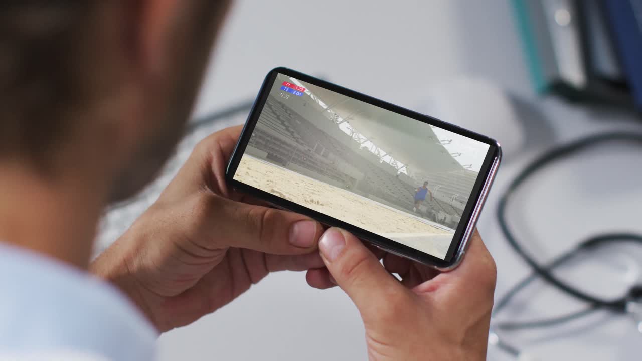 compuesto de un médico masculino viendo un evento de salto de longitud de atletismo en un smartphone