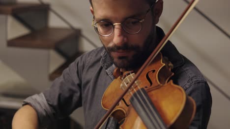 adult bearded luthier playing hand crafted violin