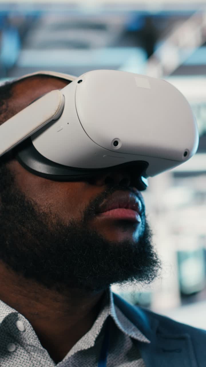 Vertical video Portrait of smiling man in data center putting VR headset on