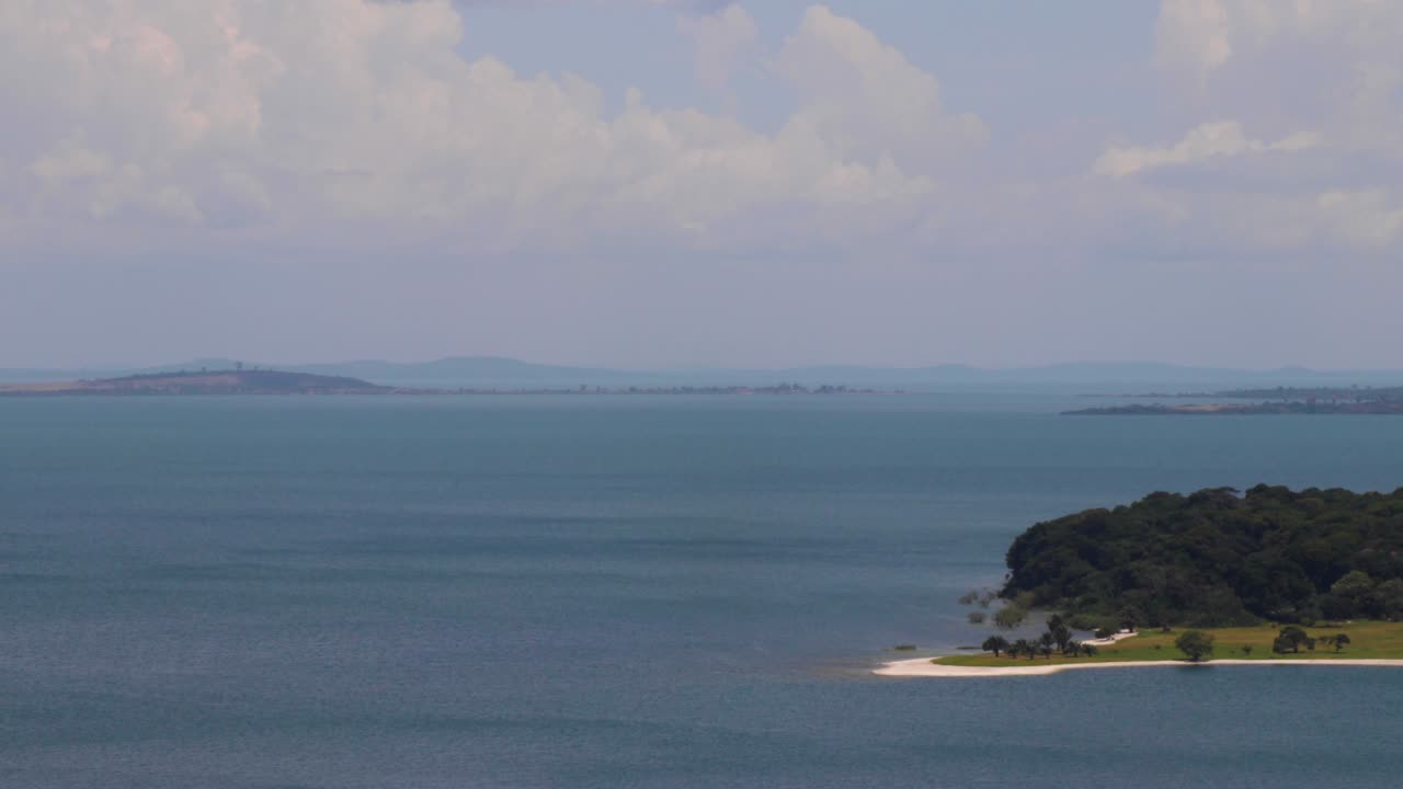 Time lapse of archipelago (Ssese Islands) in Kalangala, Uganda. View from hill of water, peninsula, faraway islands, horizon and cloudy sky over Lake Victoria. Gusts of wind on water