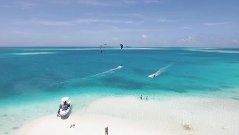 kitesurf de personas en agua cristalina turquesa y campamento de playa en playa de arena blanca, disparo de drones