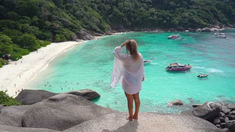 a woman walks out towards the sail rock viewpoint at the similan islands in thailand