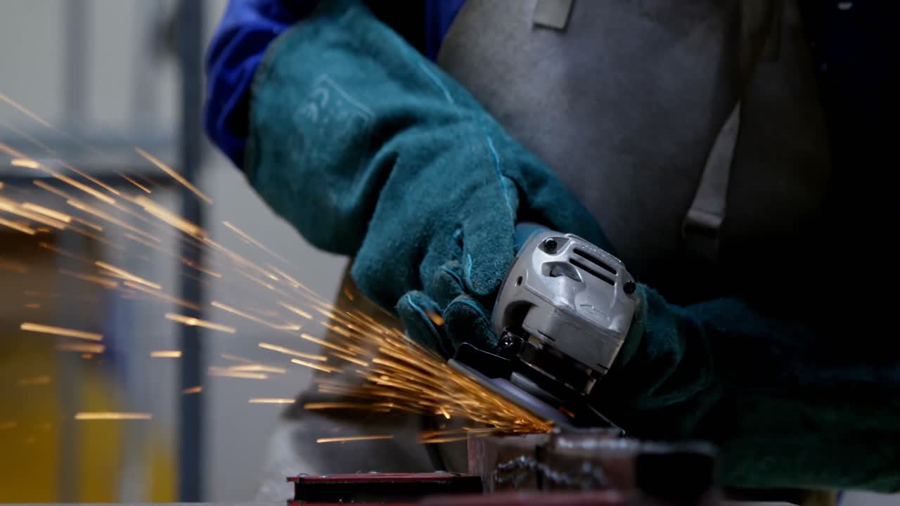 soldadora que utiliza un molinillo en el taller 4k