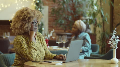 african american businesswoman working on laptop in cafe