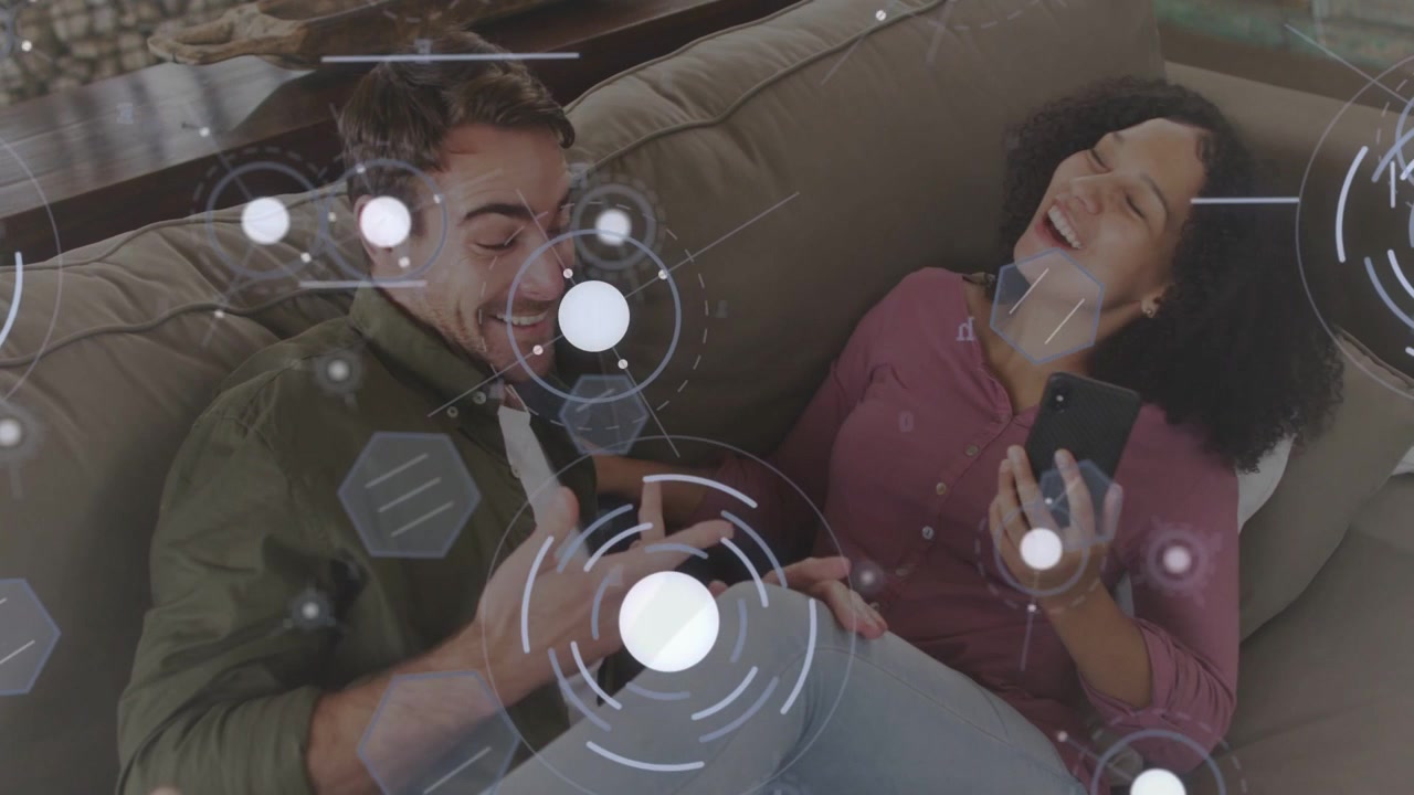 Woman holding phone tapping screen on couch man leaning laughing HUD overlaying showing tech