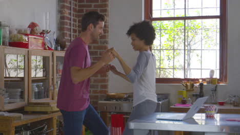 una joven pareja de raza mixta bailando en la cocina, filmada en r3d