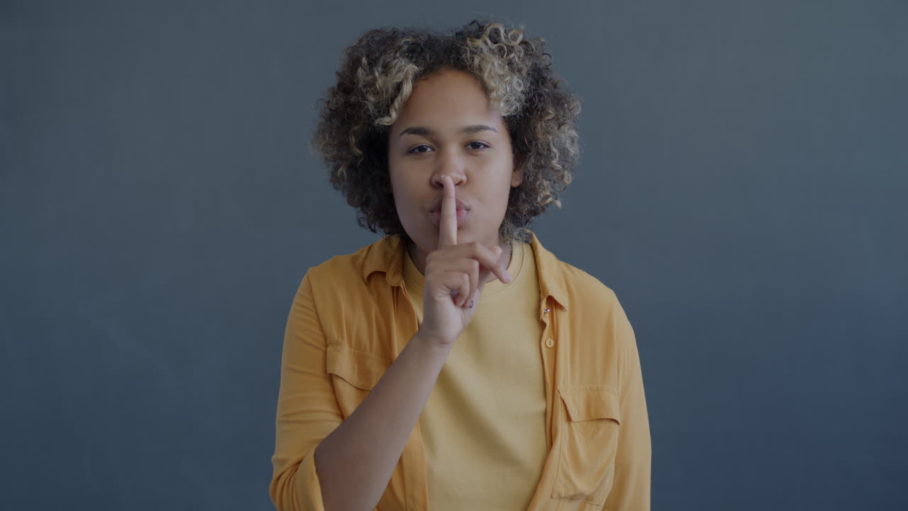 mujer haciendo gestos de silencio