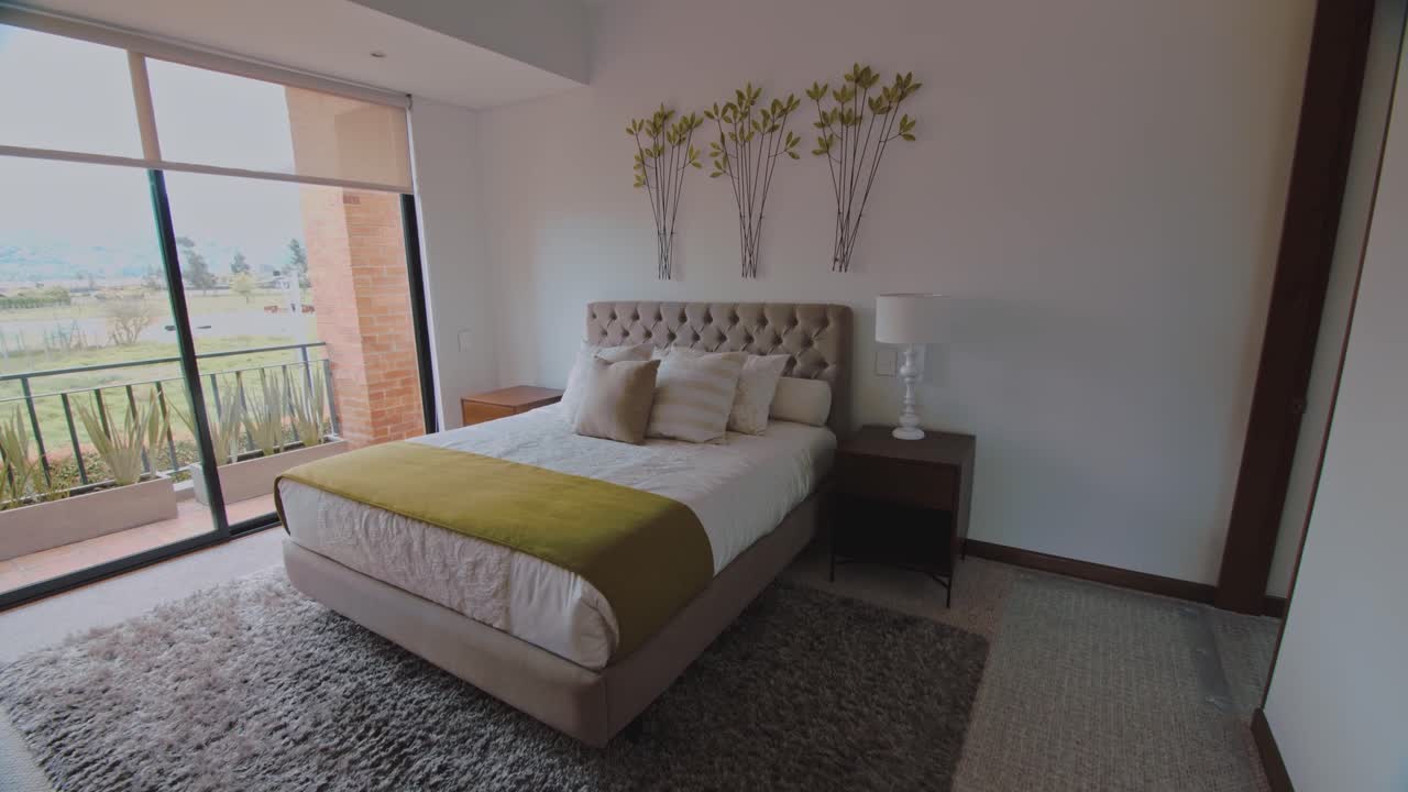 un vistazo a un dormitorio principal moderno y acogedor exquisitamente diseñado, inundado de luz natural