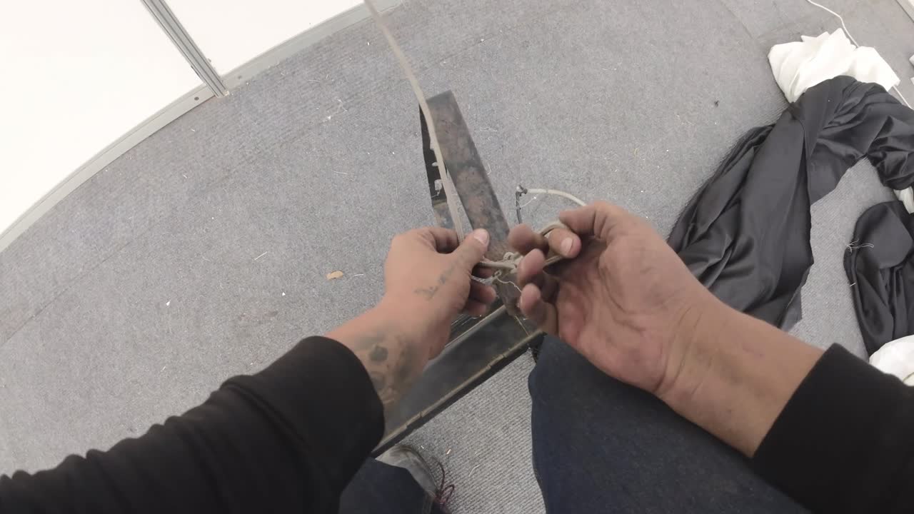 POV: operaio che lega una corda a un faretto a LED per l'allestimento di un evento