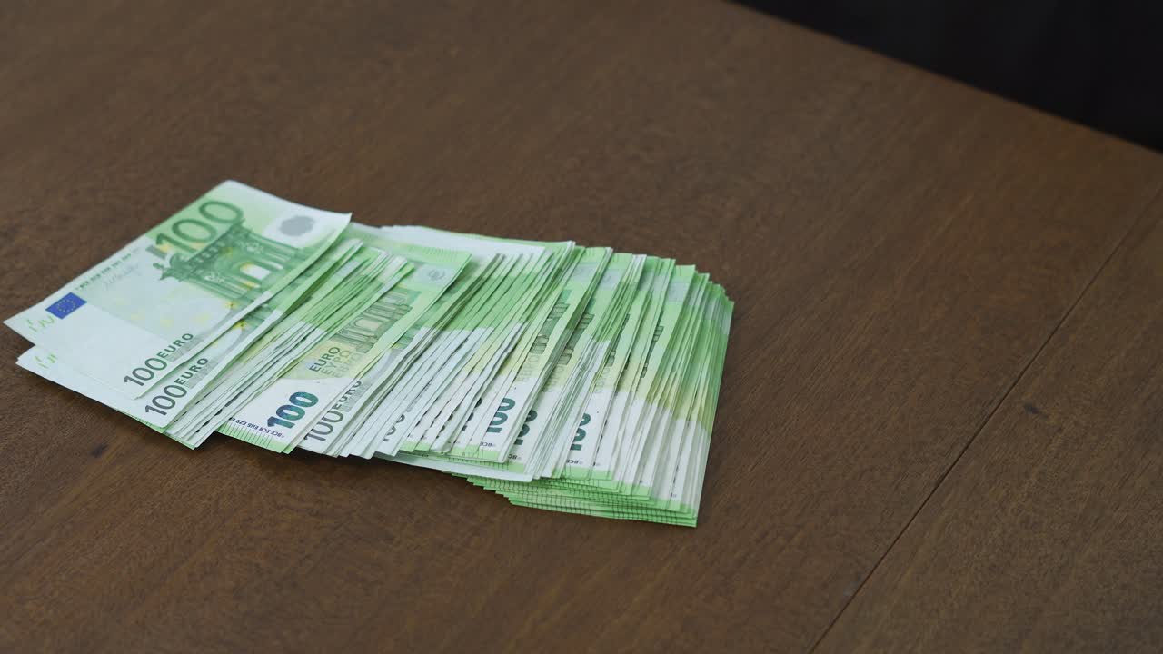 Nahaufnahme von Händen, die 100-Euro-Banknoten auf den Tisch schlagen. Konzept von Finanzkraft, Zuversicht, Kontrolle und einem starken finanziellen Statement