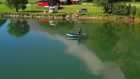 woman on the boat catches a fish on spinning in norway.
