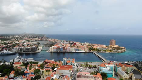 Panoramic-high-angle-aerial-dolly-establishes-Handelskade-with-coastguard-clipper-and-Queen-Emma-pontoon-bridge