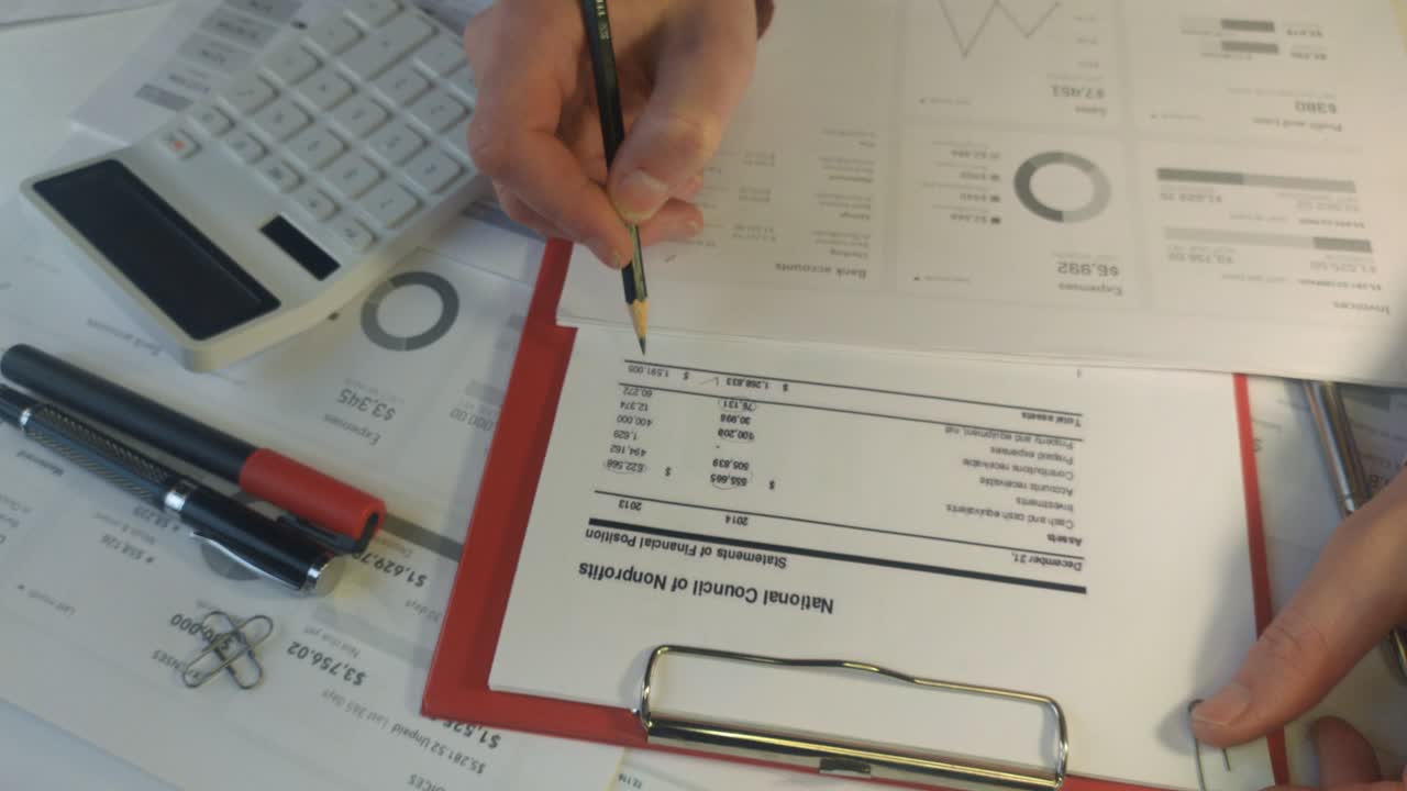 contable de mano cerrada revisa el informe financiero con un lápiz