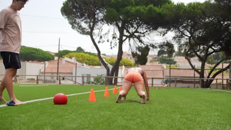 people exercising on a field with cones and a soccer ball