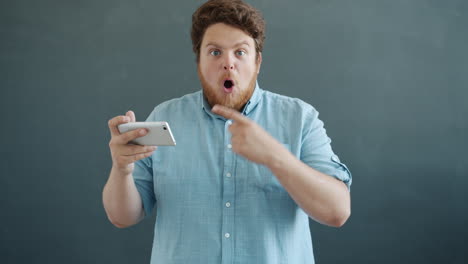 man surprised while playing a game on his phone