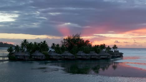stunning vibrant pink orange sunset sun rays sofitel kia ora resort bungalow villas moorea island french polynesia aerial drone cooks opunohu bay lagoon coral reef pacific ocean circle right parallax