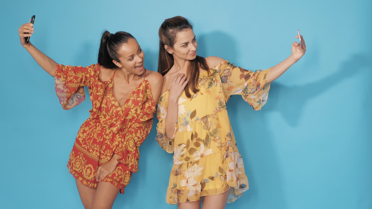 dos mujeres tomando una selfie en vestidos florales