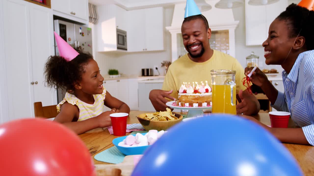 Family celebrating a birthday in kitchen at home