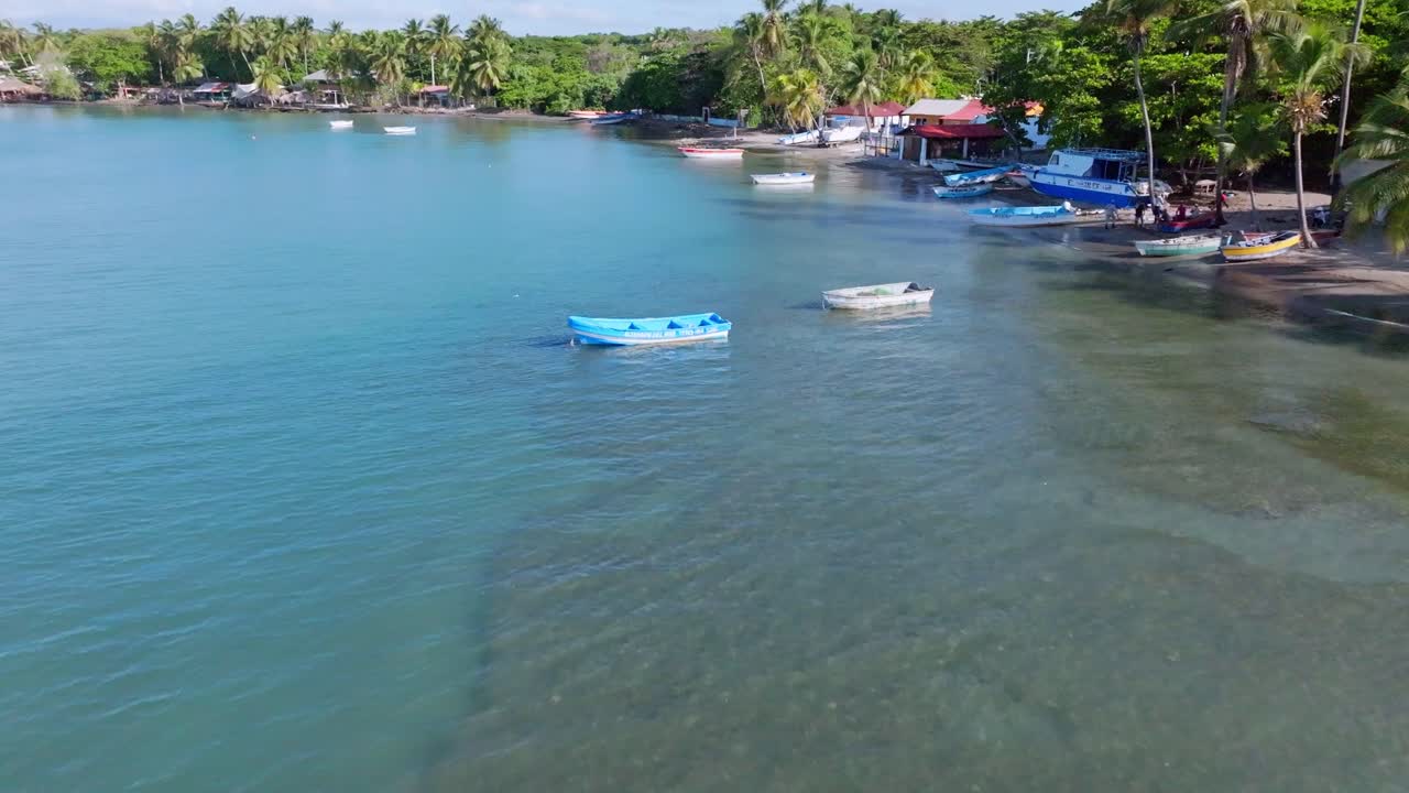 barcos flotando en aguas cristalinas de color turquesa del mar caribe en playa palenque en san cristobal, republica dominicana