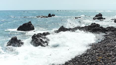 Las-Olas-Del-Océano-Chocan-Contra-Rocas-Rocosas-Irregulares-Que-Sobresalen-Del-Agua,-En-Cámara-Lenta