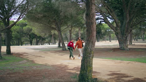 Two-hikers-walking-forest-path-look-nature-vertically.-Couple-strolling-on-park