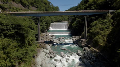 aerial under bridge and toward man-made waterfalls in kochi prefecture on the island of shikoku, japan