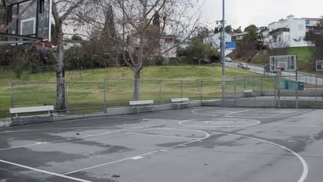 empty basketball court park overcast covid pandemic wide