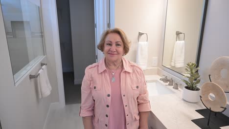 woman preps her hair and checks her appearance in a modern bathroom at her home