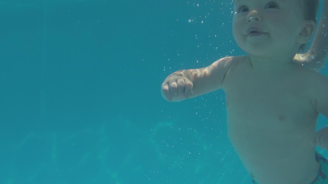 여름 휴가 에 가족 과 함께 수영장 에서 물  에서 수영 하는 아기 소년