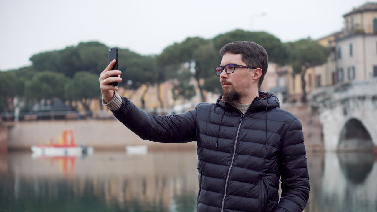 Man taking a selfie by the river in the city
