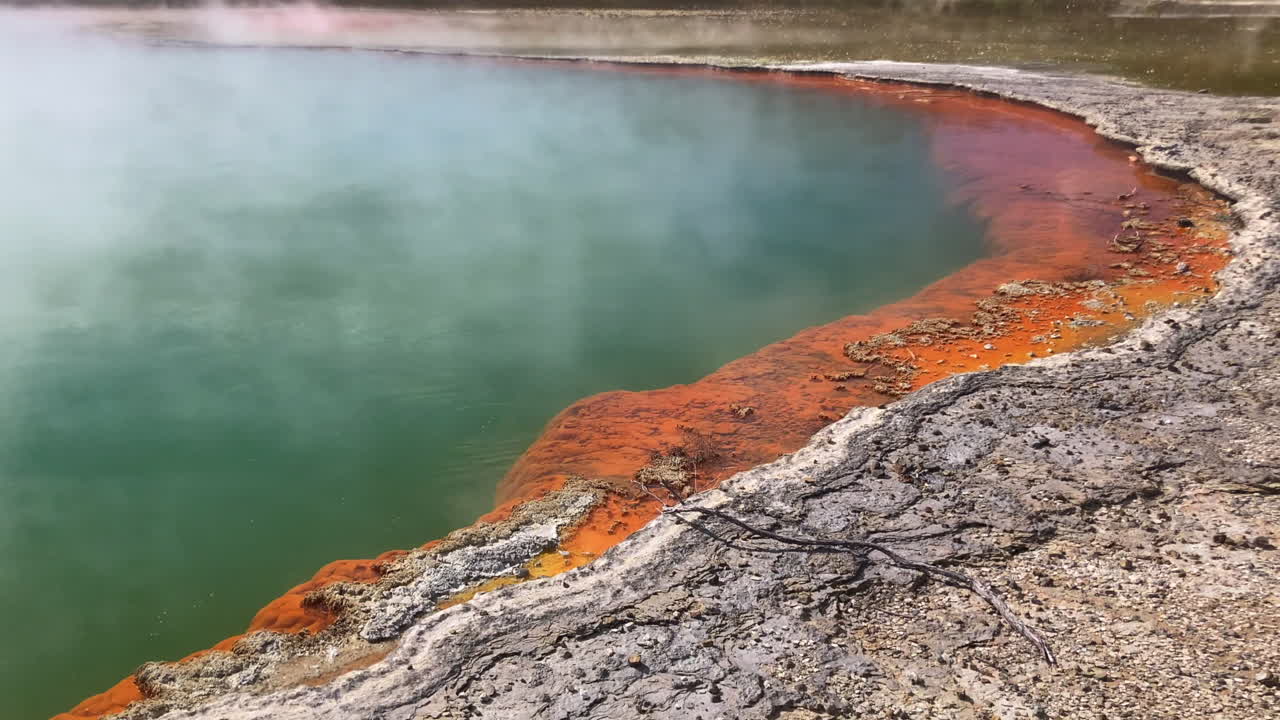 Tilt up from hardened mud to steam rising off Champagne Pool in Wai-O-tapu, New Zealand