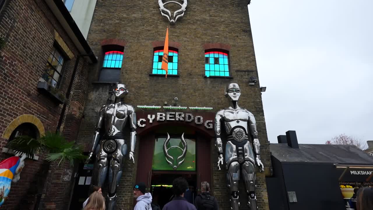 Cyberdog storefront entrance with futuristic decor and visitors entering on a cloudy day in London